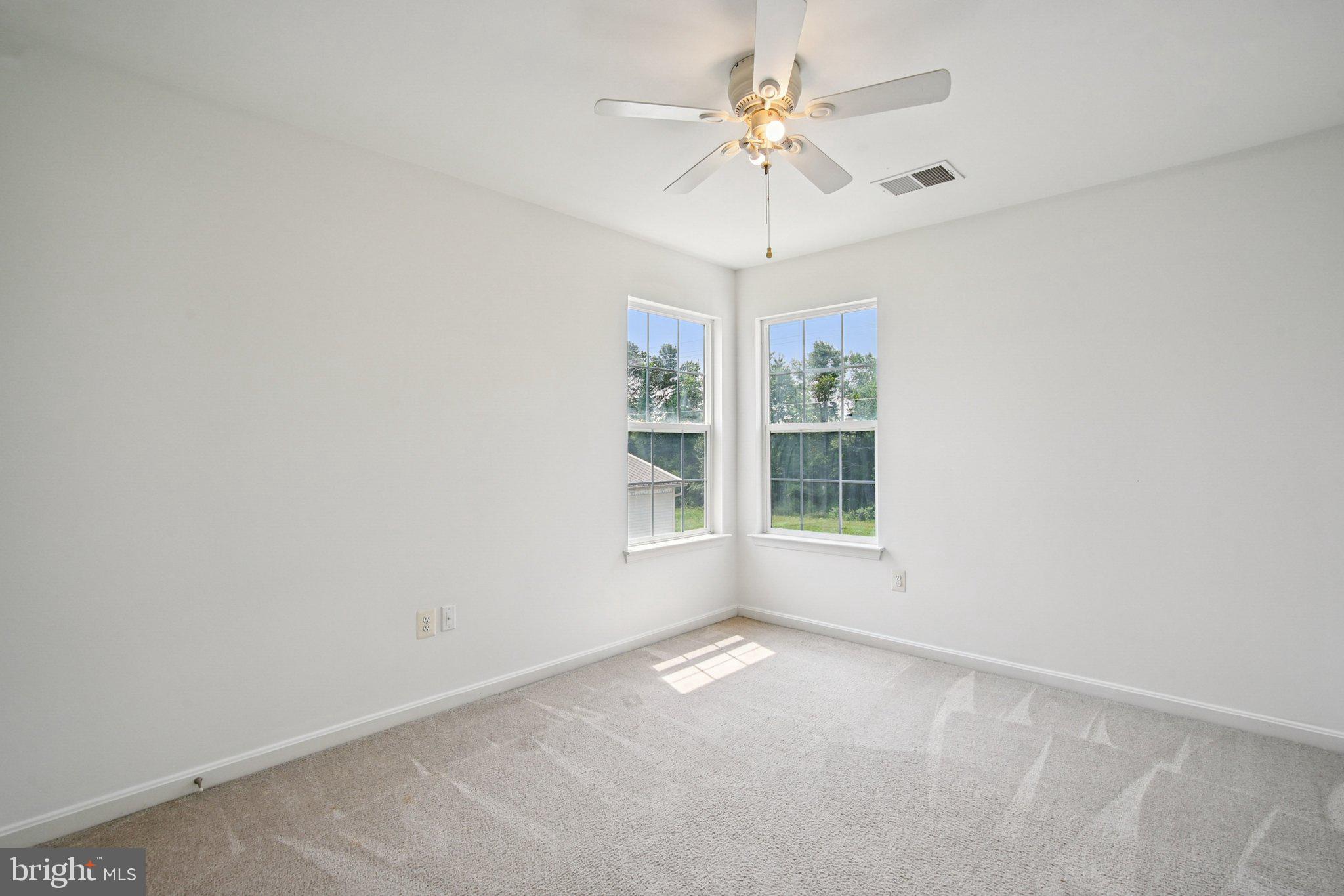 1624 Osprey Circle Cambridge, MD 21613 - Photo 24 of 45 an empty room with a chandelier fan and windows