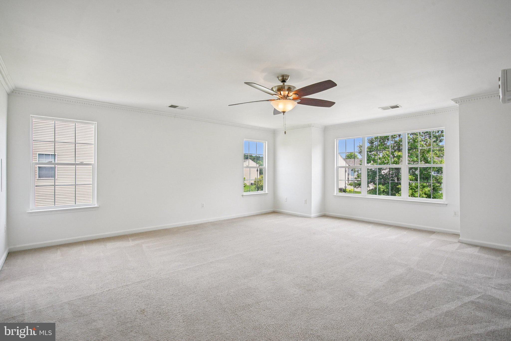 1624 Osprey Circle Cambridge, MD 21613 - Photo 34 of 45 an empty room with windows and chandelier fan