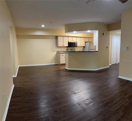 a kitchen with granite countertop a refrigerator stove and microwave