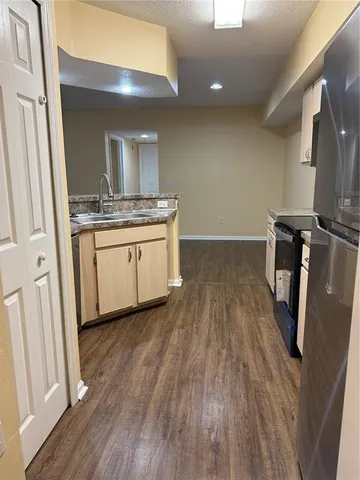 a kitchen with granite countertop a sink and a stove top oven