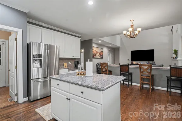 a living room with furniture kitchen and a chandelier