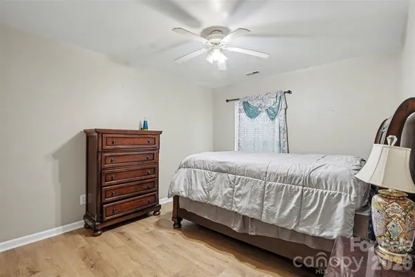 a bedroom with bed and wooden floor