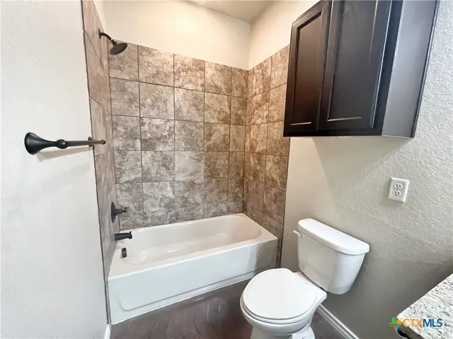 an empty room with a ceiling fan and wooden floor