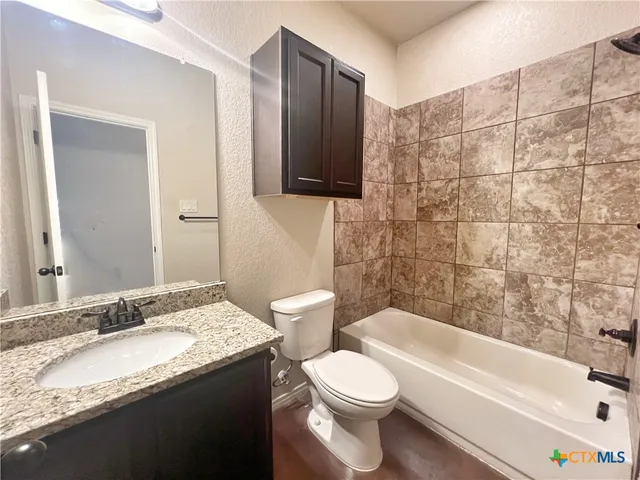 an empty room with wooden floor and fan