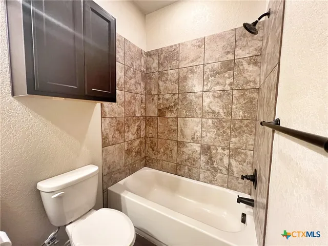 an empty room with wooden floor closet and windows