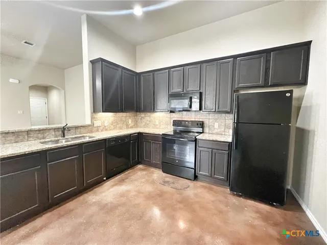 a kitchen with a refrigerator and a sink