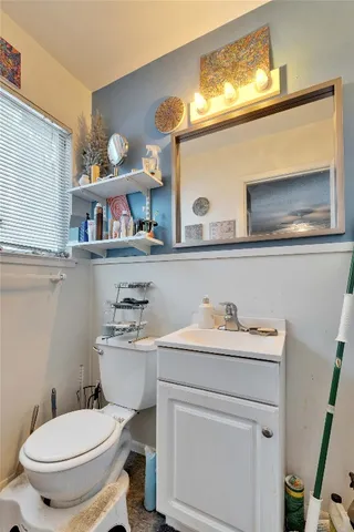 a bathroom with a toilet a sink and a mirror