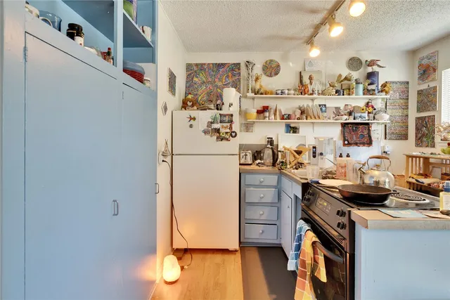 a kitchen with stainless steel appliances granite countertop a refrigerator and a stove with wooden floor
