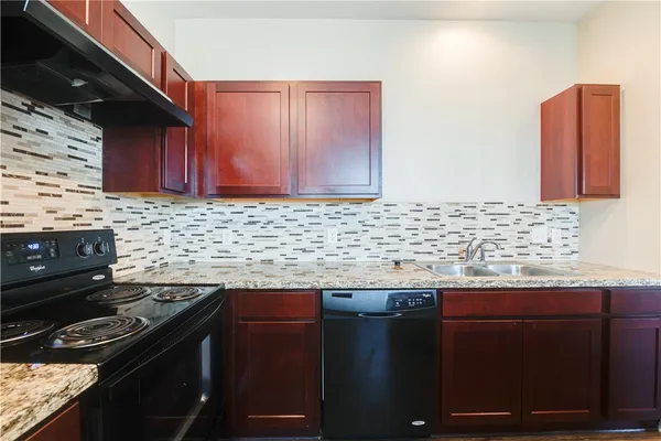 a kitchen with granite countertop a stove and a sink