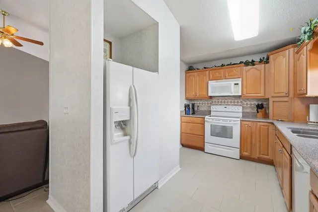 a kitchen with white cabinets and white appliances