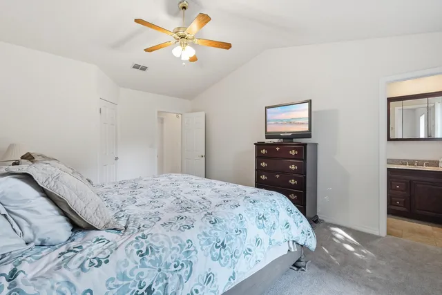 a bedroom with a bed and a ceiling fan