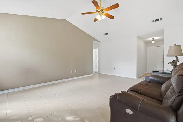 a living room with furniture and a ceiling fan