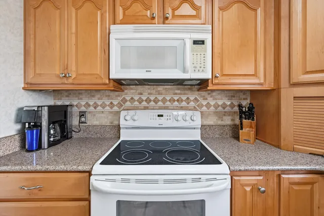 a kitchen with granite countertop cabinets and a stove