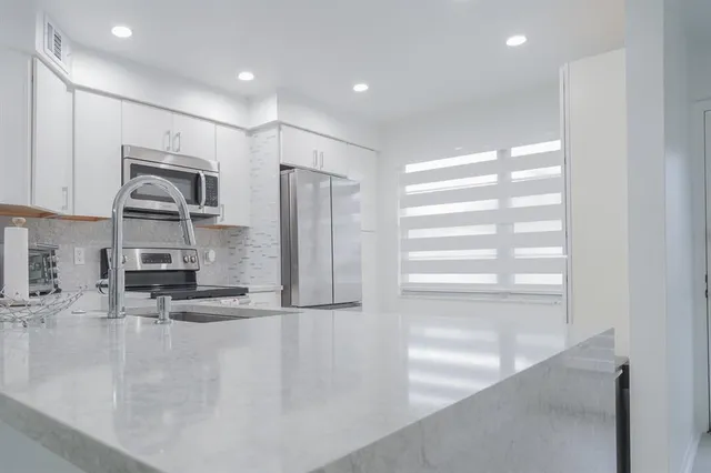 a view of a kitchen with a sink and a refrigerator