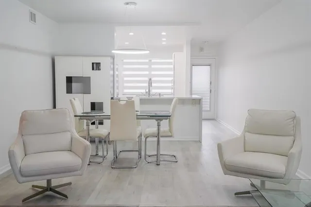 a bedroom with a bed a chair and a flat screen tv