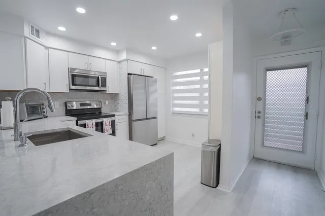 a kitchen with granite countertop a refrigerator and a sink