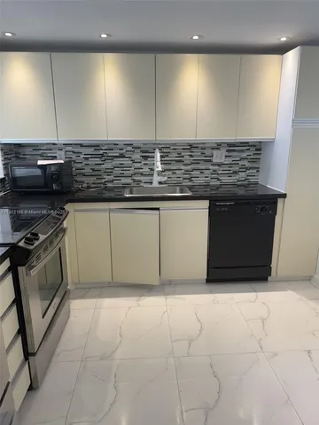 a kitchen with stainless steel appliances granite countertop a sink and a stove