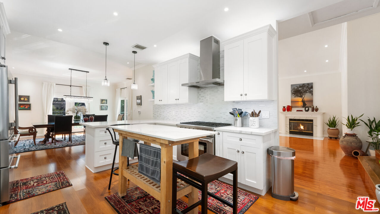 2655 Saxon Drive Los Angeles, CA 90065 - Photo 14 of 40 a kitchen with stainless steel appliances granite countertop a table chairs refrigerator and cabinets