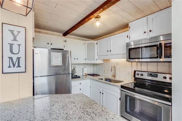 a kitchen with stainless steel appliances a refrigerator sink and cabinets