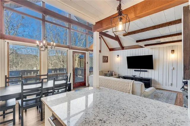 a living room with furniture a flat screen tv and a floor to ceiling window