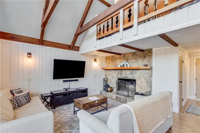 a living room with furniture a fireplace and a flat screen tv