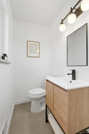 a bathroom with a toilet sink vanity and mirror