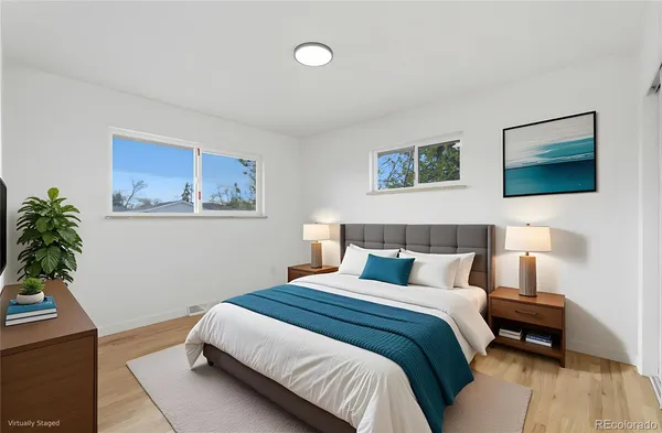 a bedroom with bed and a painting on the wall