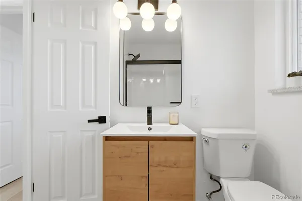 a bathroom with a sink vanity mirror and toilet