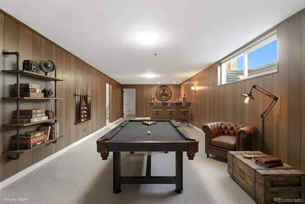 a room with furniture pool table and window