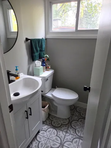 a bathroom with a toilet sink and mirror