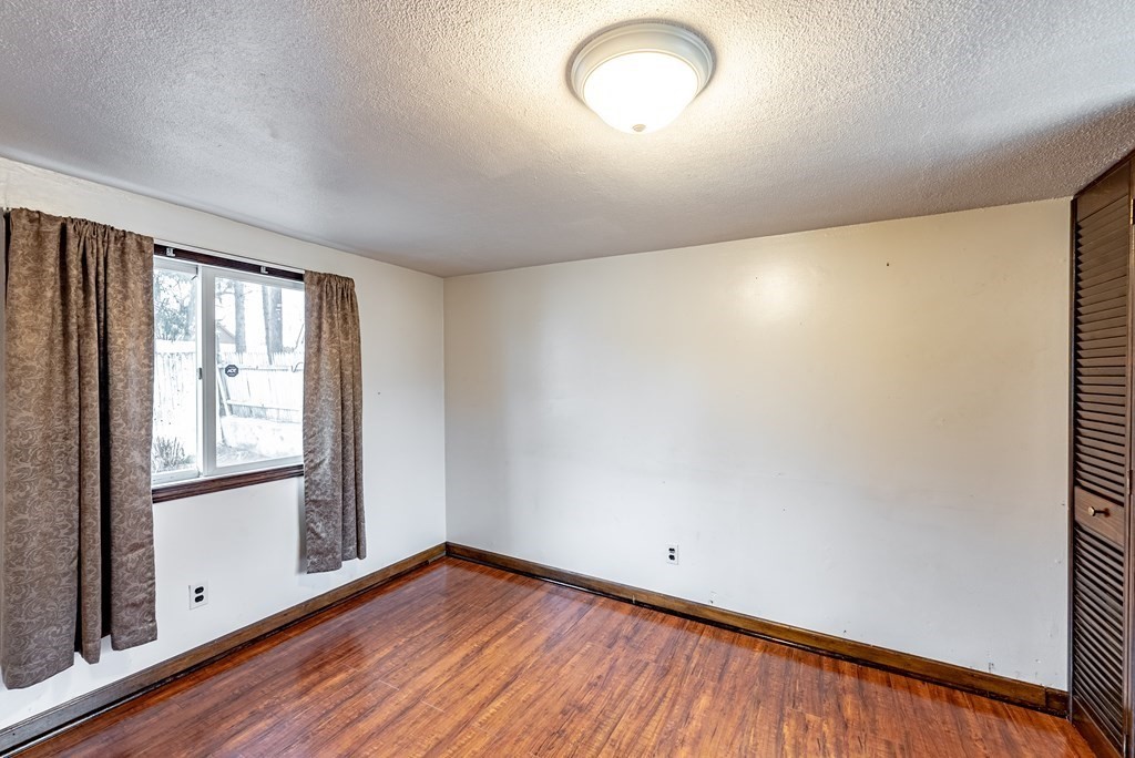 51 Littleton Street Springfield, MA 01104 - Photo 25 of 36 an empty room with wooden floor and windows