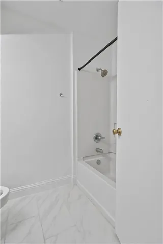 a view of an empty room with a ceiling fan and window