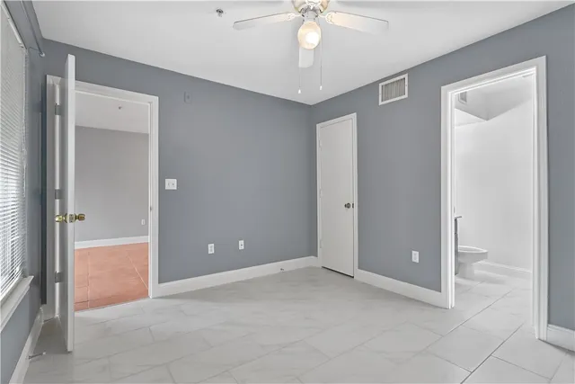 a view of an empty room and chandelier fan