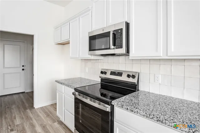 an empty room with closet and windows