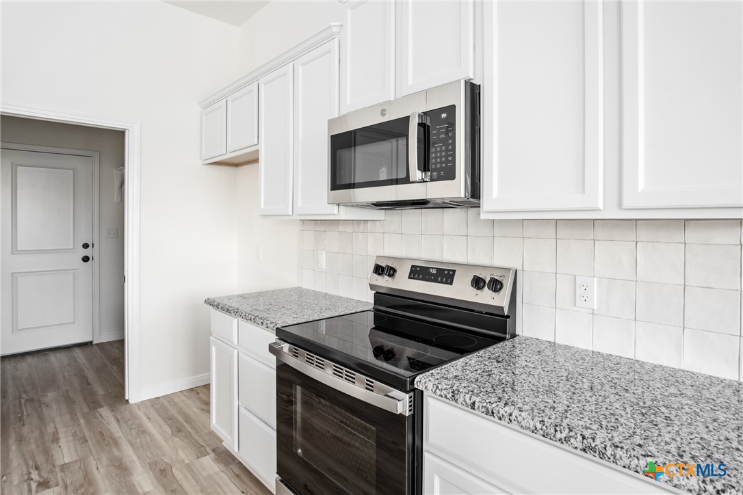 1013 Lago Azul Lane Temple, TX 76504 - Photo 14 of 32 a kitchen with a stove and a microwave
