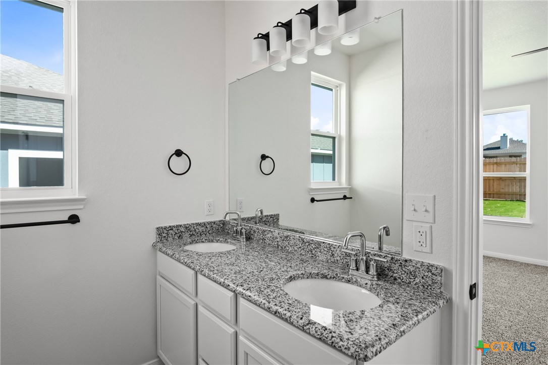 1013 Lago Azul Lane Temple, TX 76504 - Photo 17 of 32 a bathroom with a granite countertop sink and a mirror