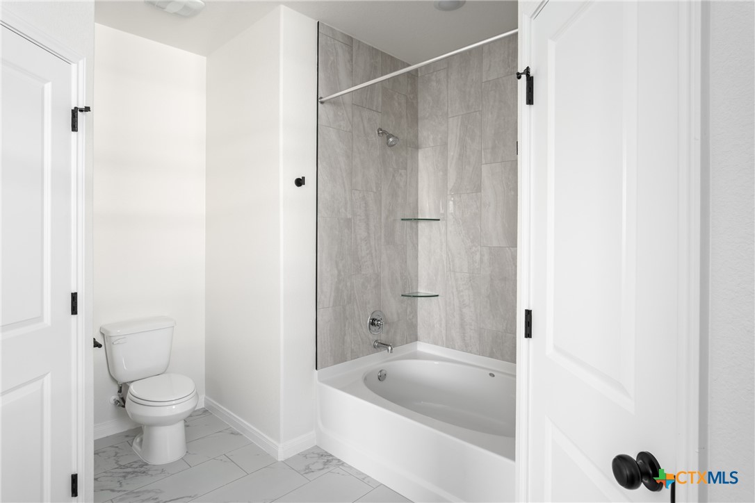 1013 Lago Azul Lane Temple, TX 76504 - Photo 18 of 32 a bathroom with a tub a toilet and a shower