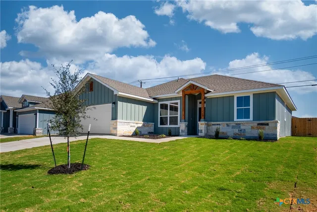 a view of a house with a yard and sitting area