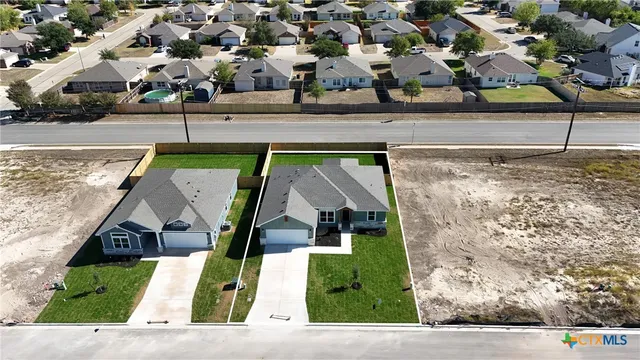 a view of a house with a small yard and sitting area