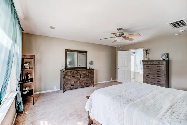 a bedroom with a large bed and a chandelier