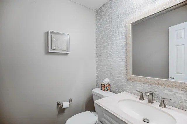 a bathroom with a sink mirror and toilet