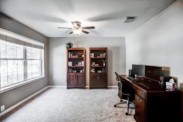 a view of a workspace with furniture and a window