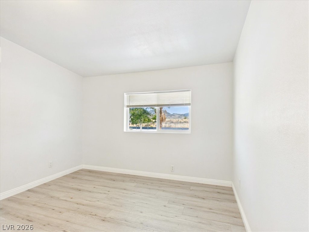 4081 Retread Road Pahrump, NV 89048 - Photo 28 of 98 Laminate flooring and a window with blinds define this accommodating bedroom space.