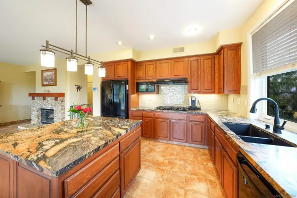 a kitchen with kitchen island granite countertop a sink stove and refrigerator