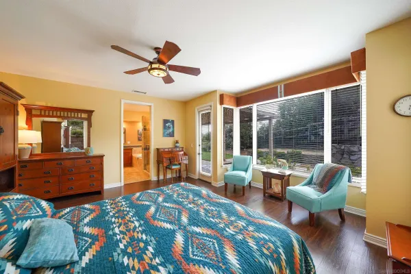 a bedroom with furniture and a large window