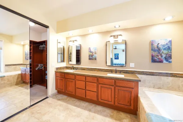 a spacious bathroom with a tub sink and mirror