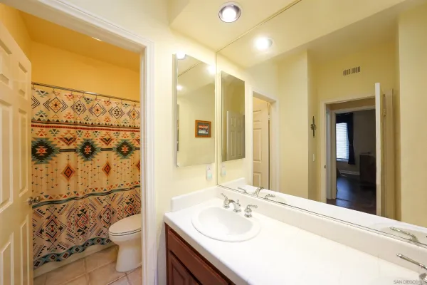 a bathroom with a double vanity sink toilet and shower
