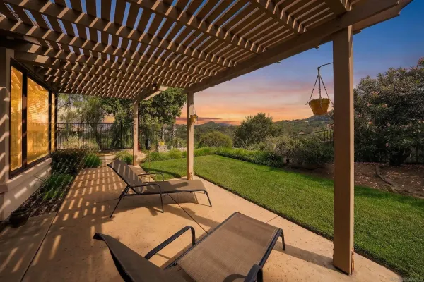 a view of yard from deck with patio