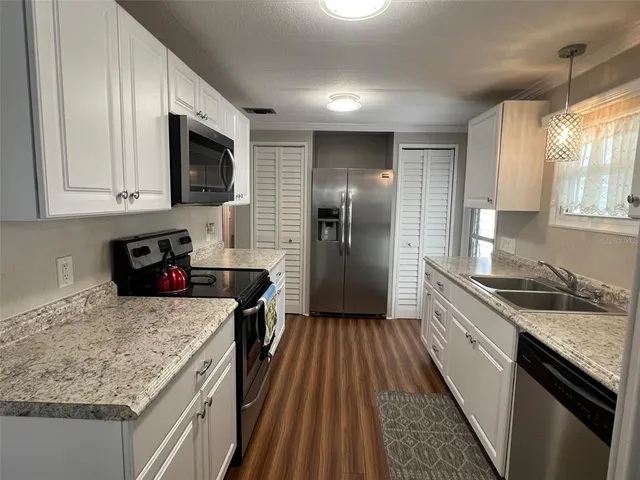 a kitchen with a sink stove top oven and refrigerator
