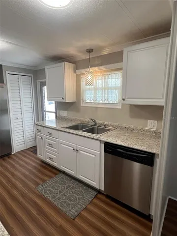 a kitchen with granite countertop stainless steel appliances a sink stove and cabinets